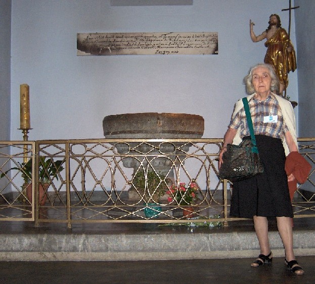 Mia mamma davanti al fonte battesimale in cui fu battezzata Santa Bernadette Soubirous